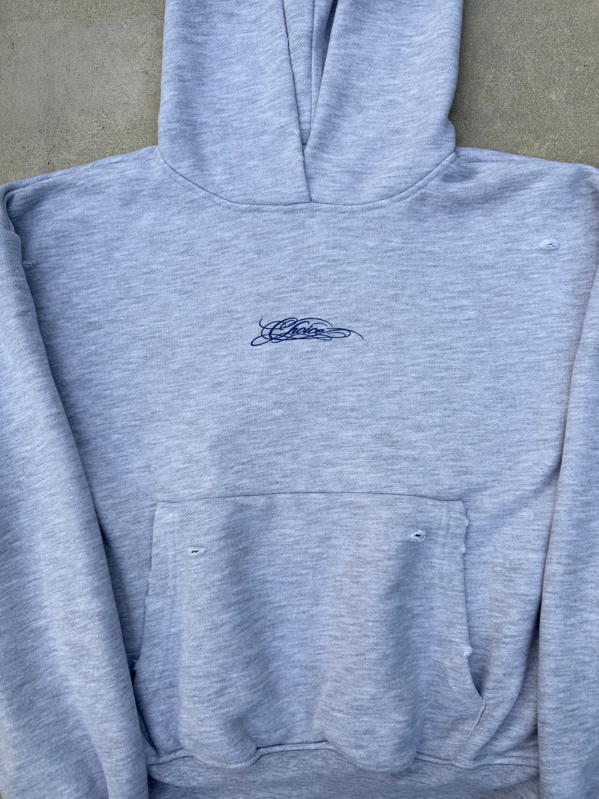 CHOICE Hoodie in heather grey — close-up of chest script and distressed pocket